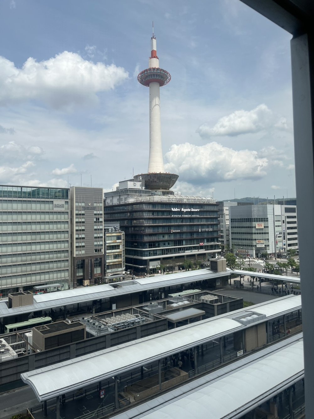 Kyoto Tower seen from Kyoto Station on a bright day with the station platforms below